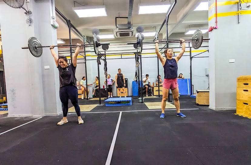 CrossFit athletes performing overhead barbell snatch at Actualize CrossFit Singapore