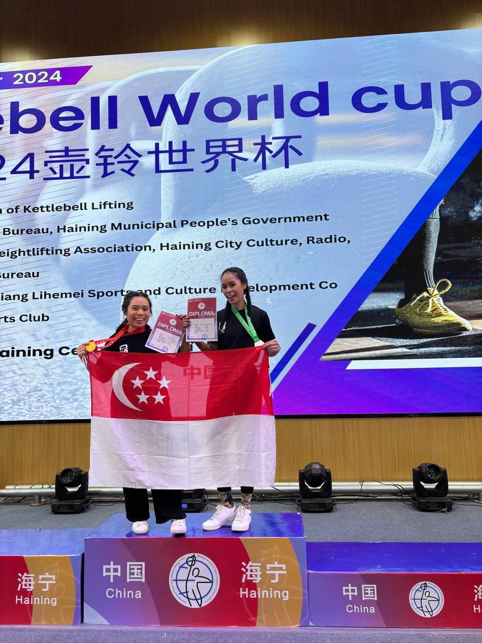 Eugenia Chan at IUKL Kettlebell World Cup 2024 China with Singapore flag