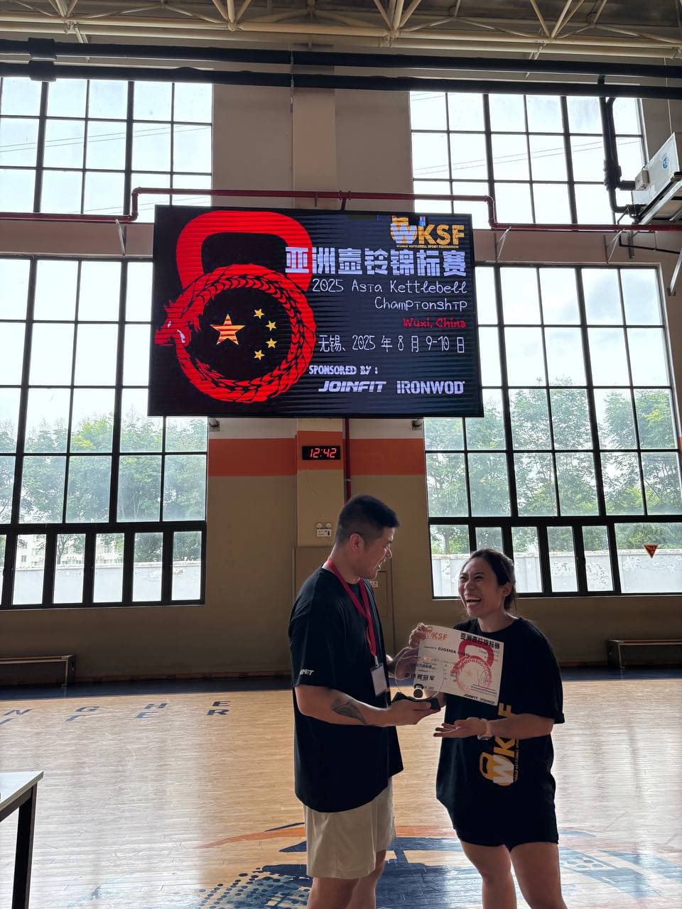 Eugenia Chan receiving award at WKSF Asia Kettlebell Championship 2025 Wuxi China